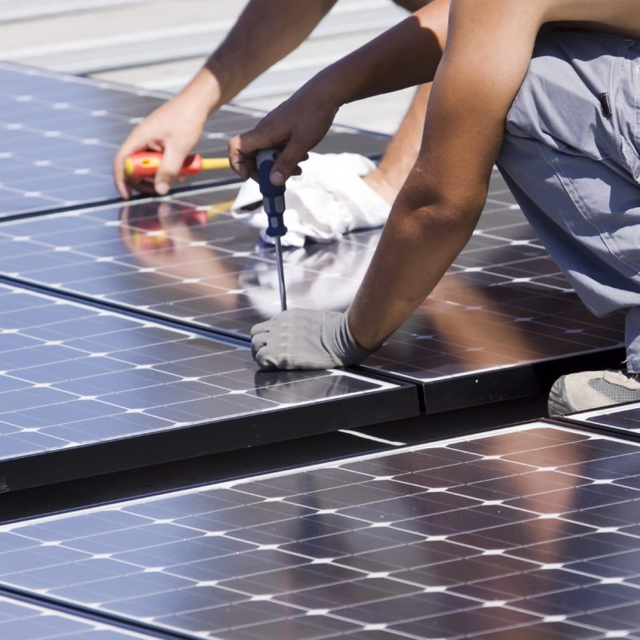 Installation de panneaux solaires par un technicien sur un toit.